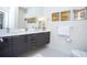 Modern bathroom featuring dual sinks, sleek cabinetry, contemporary lighting, and fixtures at 17419 Placidity Ave, Clermont, FL 34714