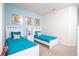 Charming bedroom featuring two twin beds with teal bedding and stylish decor at 17419 Placidity Ave, Clermont, FL 34714
