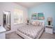 Cozy bedroom with blue accent wall, patterned bedding, and ample natural light from the window at 17419 Placidity Ave, Clermont, FL 34714
