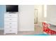 Bright bedroom with a white dresser and mounted TV for comfortable and modern living at 17419 Placidity Ave, Clermont, FL 34714