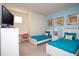 Cheerful bedroom has twin beds, bright blue accents, and a work desk, perfect for  at 17419 Placidity Ave, Clermont, FL 34714