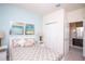 Cozy bedroom featuring neutral decor, stylish bedding, and an adjacent bathroom for added convenience at 17419 Placidity Ave, Clermont, FL 34714
