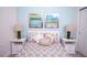 Well-decorated bedroom featuring matching nightstands, lamps, and artwork above the headboard at 17419 Placidity Ave, Clermont, FL 34714