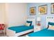 Bright bedroom with twin beds, blue accents, and a study area creating a cheerful retreat at 17419 Placidity Ave, Clermont, FL 34714