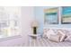 Bright bedroom featuring a window with blinds and stylish decor, including artwork and lamps at 17419 Placidity Ave, Clermont, FL 34714