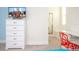 Bright bedroom with a white dresser and mounted TV for comfortable and modern living at 17419 Placidity Ave, Clermont, FL 34714