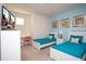 Cheerful bedroom has twin beds, bright blue accents, and a work desk, perfect for  at 17419 Placidity Ave, Clermont, FL 34714