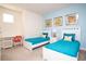 Cozy bedroom has twin beds, blue accents, and a desk creating a cheerful atmosphere at 17419 Placidity Ave, Clermont, FL 34714