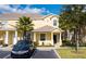 Charming two-story yellow townhome featuring a well-maintained front lawn and covered front porch at 17419 Placidity Ave, Clermont, FL 34714