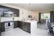 Modern kitchen open to the living room featuring stainless steel appliances and a spacious island for seamless entertaining at 17419 Placidity Ave, Clermont, FL 34714