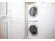 Modern stacked washer and dryer offer convenience in this well-lit laundry space at 17419 Placidity Ave, Clermont, FL 34714