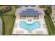 Aerial view of a kidney-shaped pool and spa in an enclosed recreational area with solar panels at 17419 Placidity Ave, Clermont, FL 34714