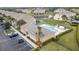 Aerial view of community pool and spa with lounge chairs and solar panels in a fenced area at 17419 Placidity Ave, Clermont, FL 34714