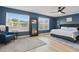 Well-lit bedroom with large windows, ceiling fan, accent chair, and hard wood floors at 1758 Bobtail Dr, Maitland, FL 32751