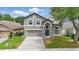 Inviting two-story home with manicured lawn, features a two-car garage and an arched entryway at 1758 Bobtail Dr, Maitland, FL 32751