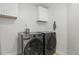 Well-lit laundry room with modern front-load washer and dryer and white cabinets at 1758 Bobtail Dr, Maitland, FL 32751