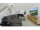 Bright living room featuring a comfortable gray sectional sofa, white walls, and a staircase at 1758 Bobtail Dr, Maitland, FL 32751