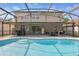 Backyard pool and patio area with black metal framed screened enclosure and a stainless grill at 1758 Bobtail Dr, Maitland, FL 32751