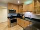 Modern kitchen with wooden cabinets, stainless steel appliances, and black countertops at 200 Maitland Ave # 232, Altamonte Springs, FL 32701