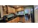 A stylish kitchen boasts wooden cabinetry, dark countertops, stainless steel appliances, and a view to the dining room at 200 Maitland Ave # 232, Altamonte Springs, FL 32701