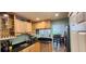 A stylish kitchen boasts wooden cabinetry, dark countertops, stainless steel appliances, and a view to the dining room at 200 Maitland Ave # 232, Altamonte Springs, FL 32701