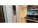 A modern laundry room features a stacked washer and dryer, a laminate floor, and convenient shelving at 200 Maitland Ave # 232, Altamonte Springs, FL 32701