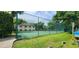 Community tennis court featuring a green surface, with lush landscaping at 200 Maitland Ave # 232, Altamonte Springs, FL 32701