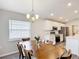 Bright dining area connected to the kitchen featuring natural light and a modern chandelier at 2005 Noble Dr, Davenport, FL 33837
