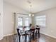 Dining room with wood-look flooring, a table set for six, and large windows that provide natural light at 2005 Noble Dr, Davenport, FL 33837