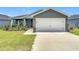 Beautiful single-story home with a two-car garage, manicured lawn, and freshly poured driveway at 2005 Noble Dr, Davenport, FL 33837