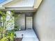 Welcoming entryway with a gray front door, garden bed and a concrete path at 2005 Noble Dr, Davenport, FL 33837