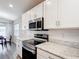 Modern kitchen with stainless steel appliances, marble countertops, and a view into the dining area at 2005 Noble Dr, Davenport, FL 33837