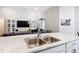 Kitchen island with a stainless steel sink, modern faucet, and an open layout to the living room at 2005 Noble Dr, Davenport, FL 33837