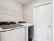 Functional laundry room features modern washer and dryer units with overhead shelving at 2005 Noble Dr, Davenport, FL 33837