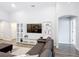Bright living room featuring a large TV, comfortable couch, and modern shelving units at 2005 Noble Dr, Davenport, FL 33837