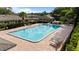 Large community pool with lounge chairs, surrounded by mature trees and hedges at 206 Diamond Cv # 106, Casselberry, FL 32707