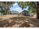 Expansive backyard with mature trees, a storage shed, and a swing set, providing plenty of room to relax and play at 2106 Altoona Ln, Deltona, FL 32738
