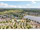 Expansive aerial view showcasing a residential community with ponds, swimming pool, and lush green spaces surrounded by trees at 2116 Truffle Ln, Casselberry, FL 32707