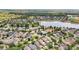 An aerial view of a community with a lake and a pool surrounded by many mature trees, and a baseball field at 2116 Truffle Ln, Casselberry, FL 32707