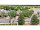 An aerial view shows a well-maintained home near a lake, mature trees and sidewalks at 2116 Truffle Ln, Casselberry, FL 32707