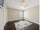 Spare bedroom with a ceiling fan, plantation shutters, and dark wood floors with a patterned area rug at 2116 Truffle Ln, Casselberry, FL 32707