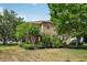 Two-story home with a beige exterior, surrounded by lush landscaping and mature trees, providing a serene and inviting atmosphere at 2116 Truffle Ln, Casselberry, FL 32707