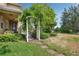 Charming home entrance with a decorative pergola, lush landscaping, and a serene garden path at 2116 Truffle Ln, Casselberry, FL 32707