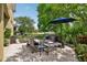 Inviting brick patio features comfortable seating under a shady umbrella, overlooking the scenic backyard at 2116 Truffle Ln, Casselberry, FL 32707
