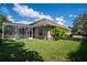 Expansive backyard featuring a screened-in pool area and lush green lawn, perfect for outdoor activities at 2232 Lake Vilma Dr, Orlando, FL 32835