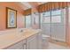 Bathroom features a shower with glass door, a sink with white cabinets and peach colored walls at 2232 Lake Vilma Dr, Orlando, FL 32835