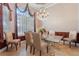 Dining room featuring a glass table with ornate chairs, chandelier, and plenty of natural light at 2232 Lake Vilma Dr, Orlando, FL 32835