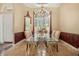 Formal dining room featuring a glass table with ornate chairs, chandelier, and plenty of natural light at 2232 Lake Vilma Dr, Orlando, FL 32835
