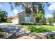 Well-manicured lawn, tall, arched windows, and a driveway leading to an attached garage at 2232 Lake Vilma Dr, Orlando, FL 32835