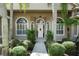 Inviting front entrance features a white door flanked by arched windows and mature landscaping at 2232 Lake Vilma Dr, Orlando, FL 32835